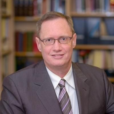 man with glasses in suit and tie